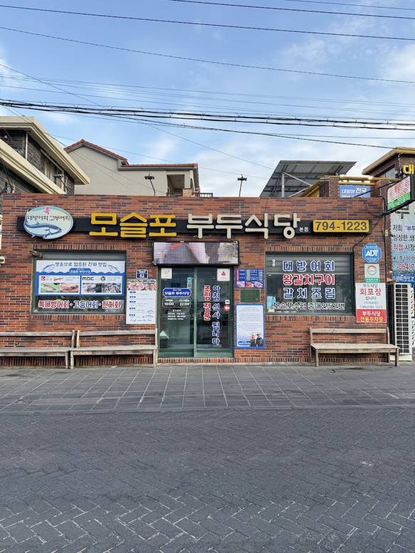 노란 간판을 단 모슬포 부두식당의 벽돌 건물 앞